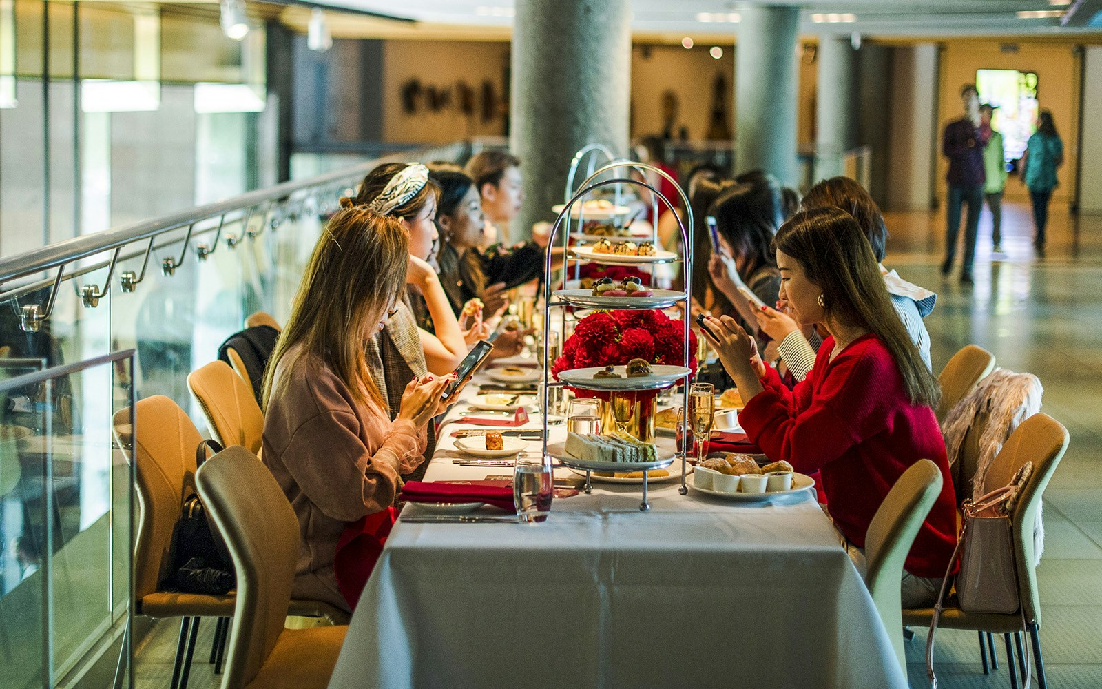 Guests enjoying high tea at National Gallery of Victoria with tiered trays of pastries.