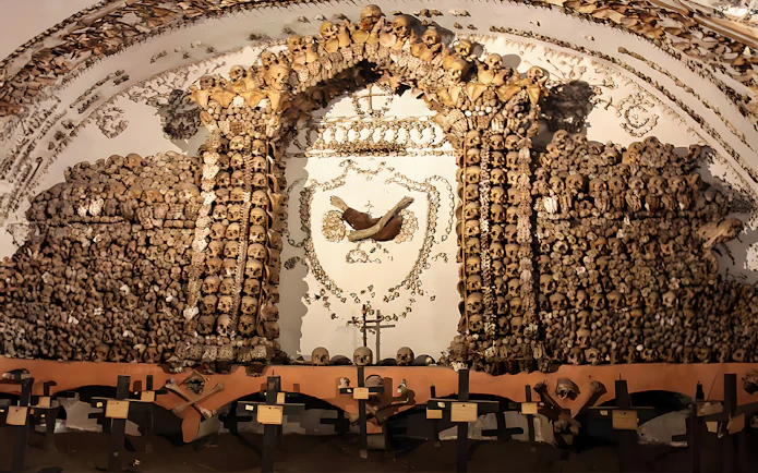 Skulls and bones arranged in a decorative pattern in a Roman Catacombs crypt.