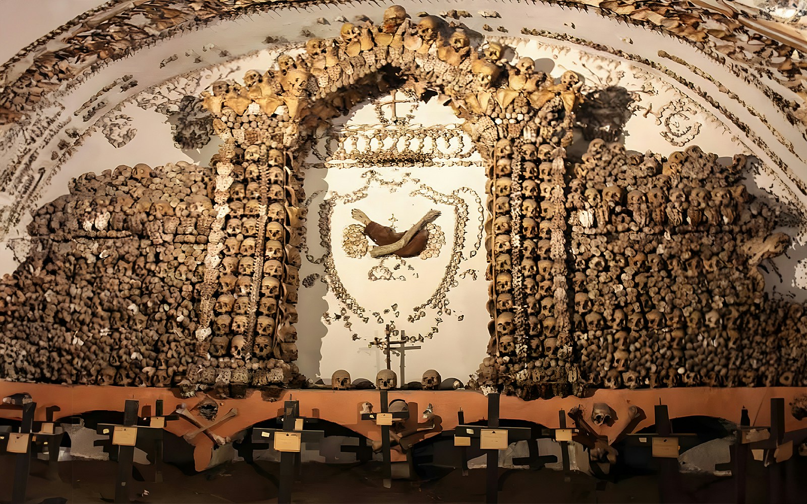 Skulls and bones arranged in a decorative pattern in a Roman Catacombs crypt.
