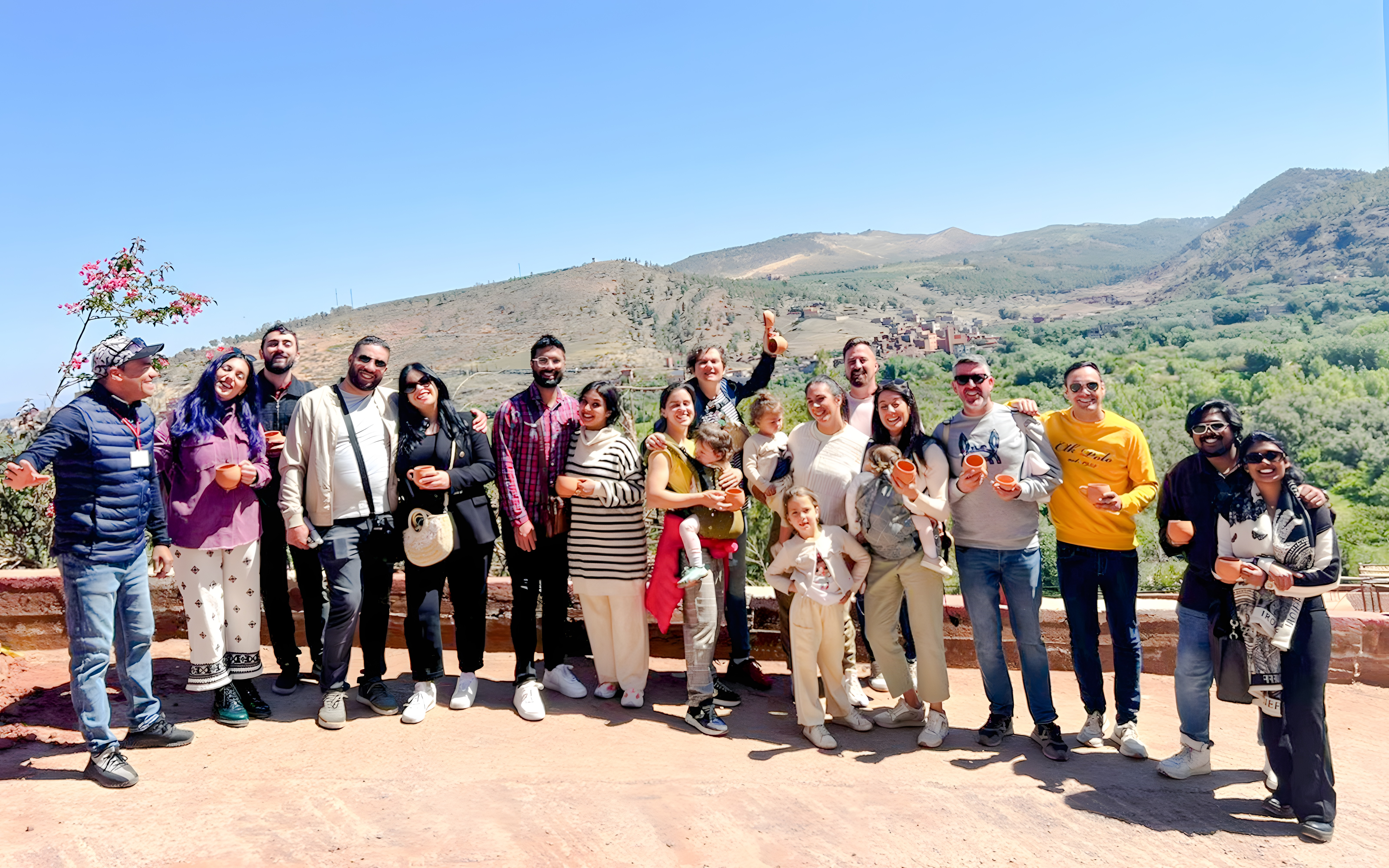 Group enjoying a scenic view in Ourika Valley, Morocco, with mountains in the background.