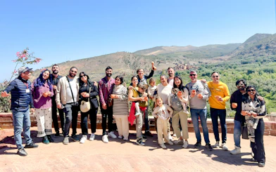 Group enjoying a scenic view in Ourika Valley, Morocco, with mountains in the background.