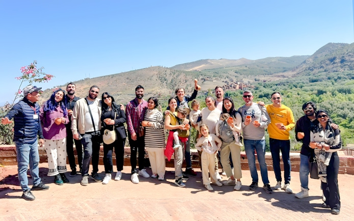 Group enjoying a scenic view in Ourika Valley, Morocco, with mountains in the background.