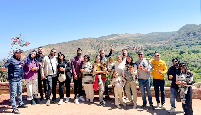 Group enjoying a scenic view in Ourika Valley, Morocco, with mountains in the background.