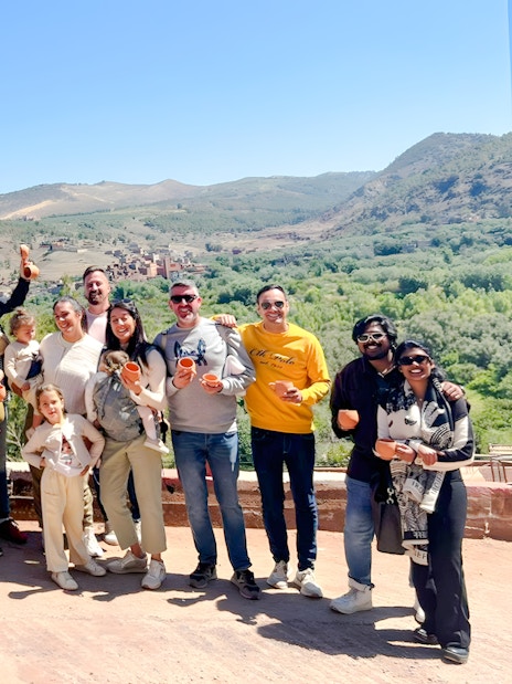 Group enjoying a scenic view in Ourika Valley, Morocco, with mountains in the background.