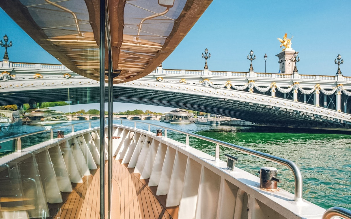 Cruise boat approaching ornate bridge on the Nile River.