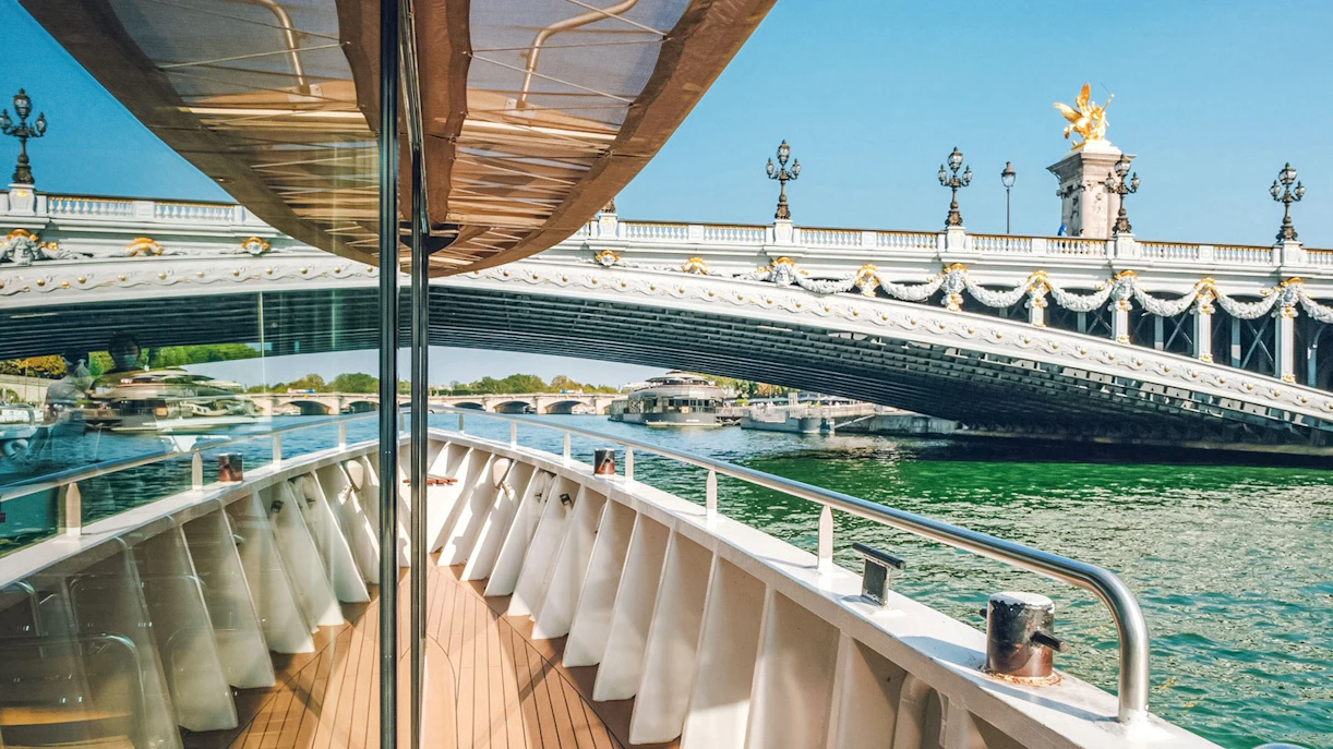 Cruise boat approaching ornate bridge on the Nile River.