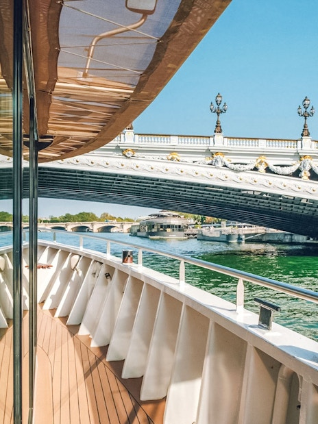 Cruise boat approaching ornate bridge on the Nile River.