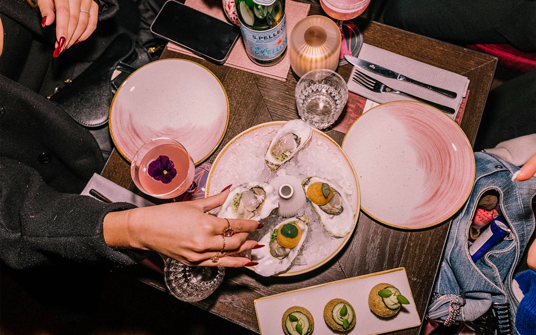 Oysters and cocktails on a table at Madam Skybar Restaurant.