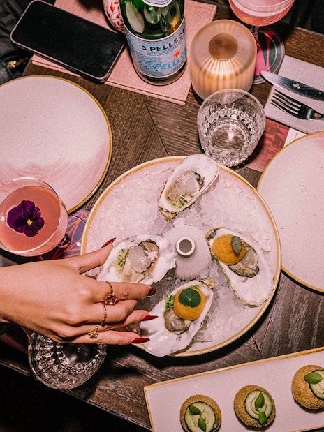 Oysters and cocktails on a table at Madam Skybar Restaurant.
