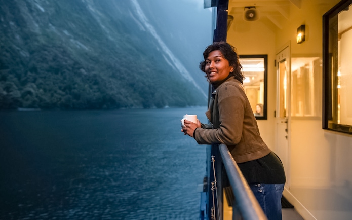 Person enjoying view from Milford Sound cruise deck.