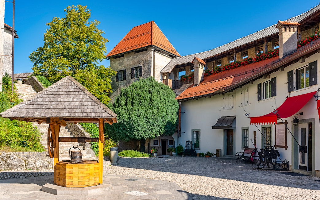 Lake Bled castle courtyard with well and historic buildings, Slovenia.