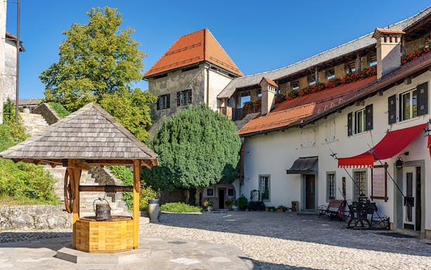 Lake Bled castle courtyard with well and historic buildings, Slovenia.