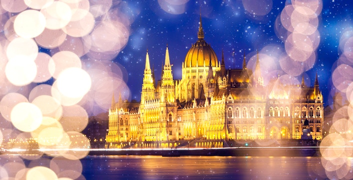 Hungarian Parliament Building illuminated at night with snow falling in Budapest, Hungary.