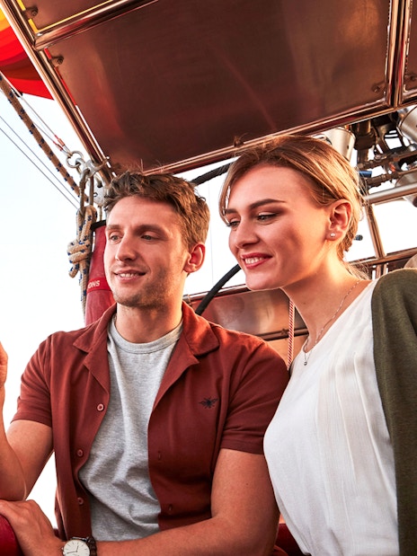 Hot air balloon ride with falconry experience, featuring a couple observing a falcon in the basket.