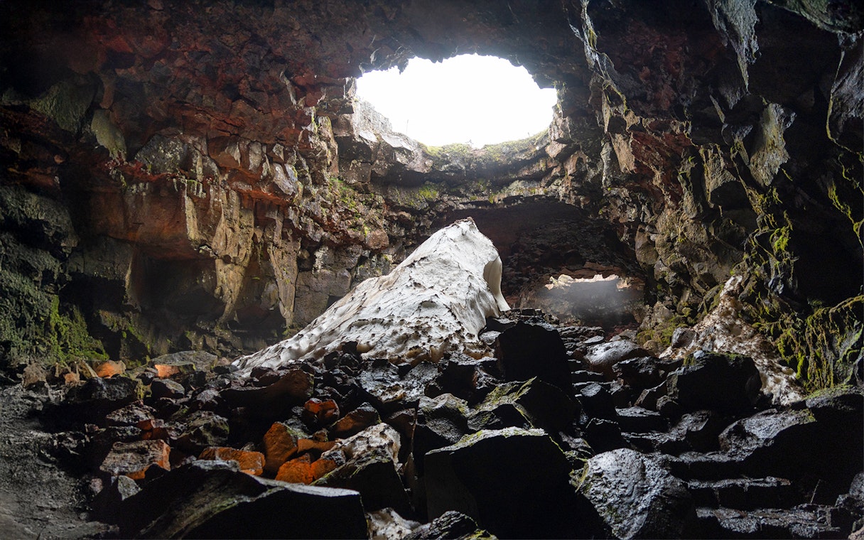 Raufarhólshellir Lava Cave interior with rock formations and natural light, Iceland.