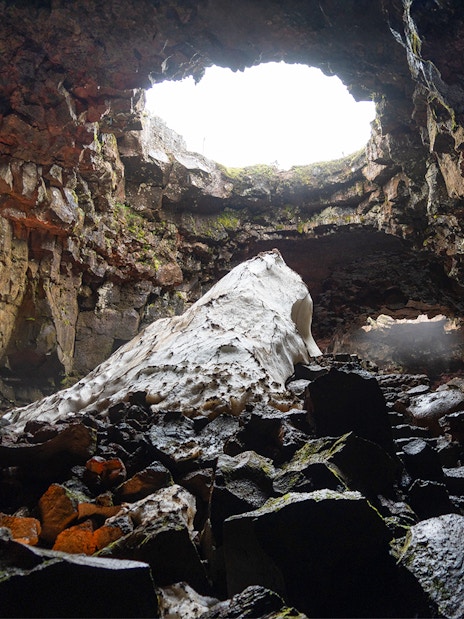 Raufarhólshellir Lava Cave interior with rock formations and natural light, Iceland.
