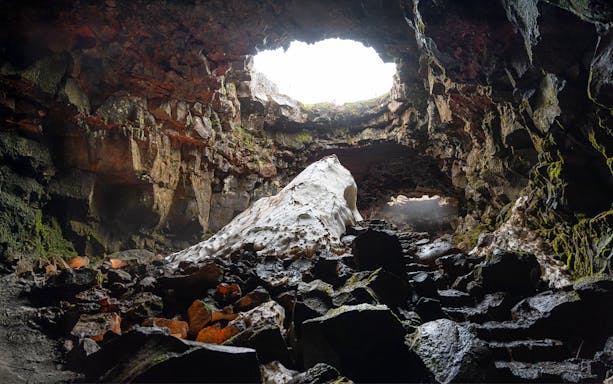 Raufarhólshellir Lava Cave interior with rock formations and natural light, Iceland.