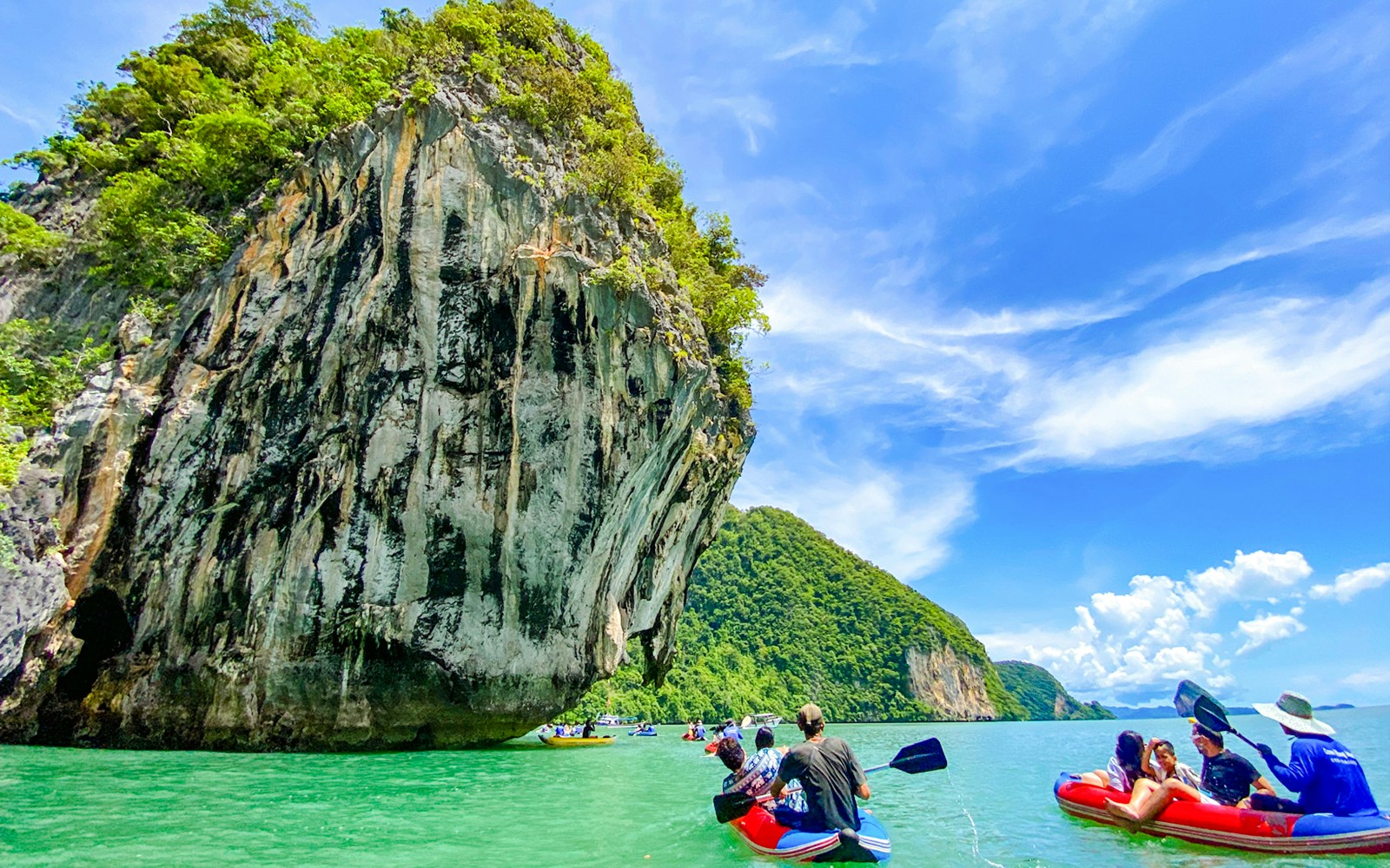 Tourists kayaking near limestone cliffs at Phang Nga Bay, with views of James Bond Island and Hong Island.