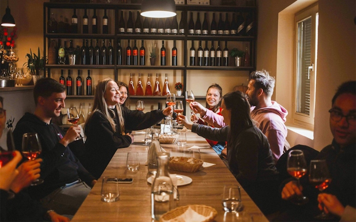 Group enjoying wine tasting at a table in Zadar during Krka National Park tour.