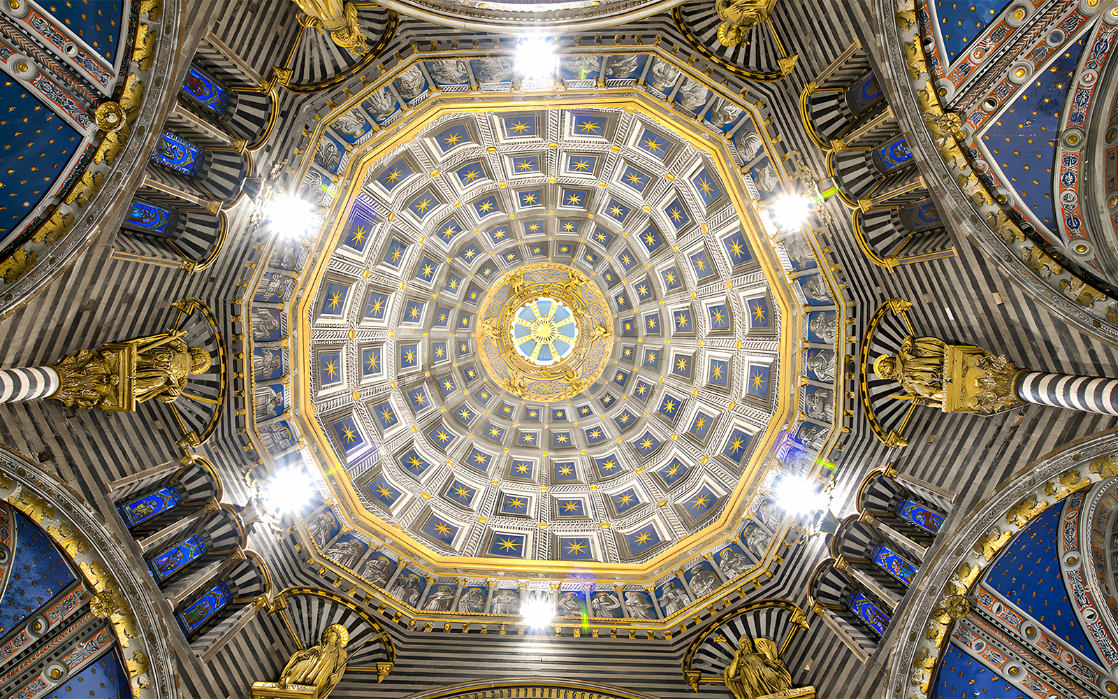 Siena Duomo dome interior with intricate gold and blue star patterns.