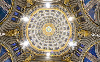 Siena Duomo dome interior with intricate gold and blue star patterns.