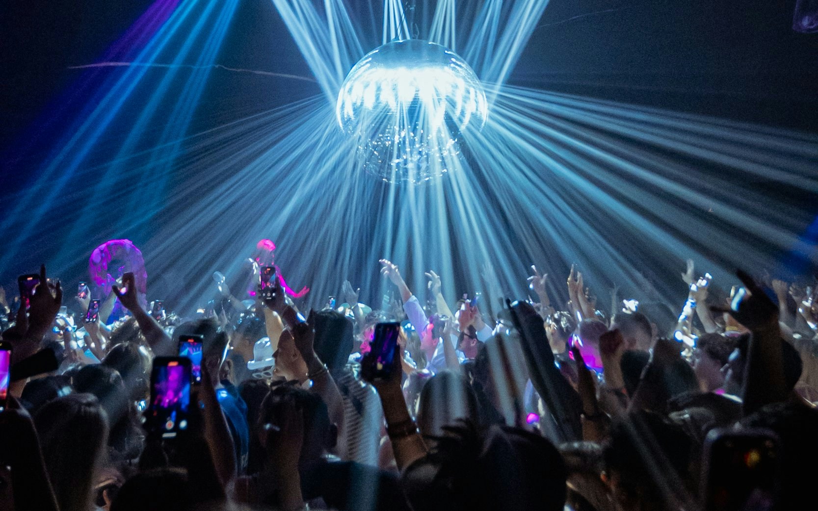 DJ performing at La Troya Club Chinois, Ibiza with crowd and light show.