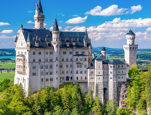 Neuschwanstein Castle in Bavaria, Germany, surrounded by lush green forest.