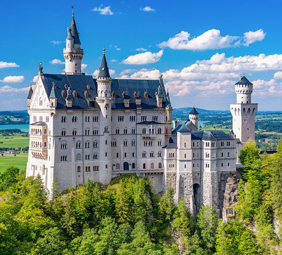 Neuschwanstein Castle in Bavaria, Germany, surrounded by lush green forest.