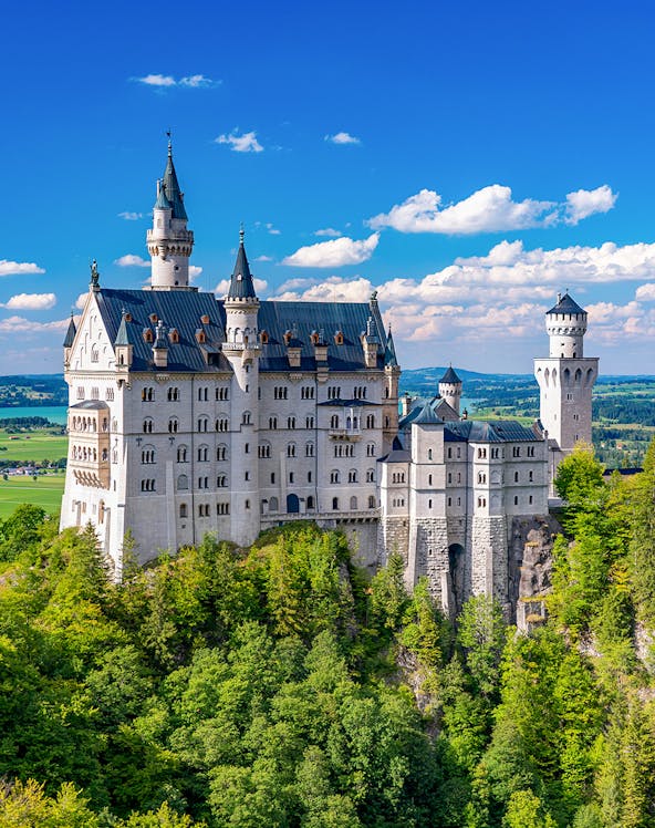 Neuschwanstein Castle in Bavaria, Germany, surrounded by lush green forest.