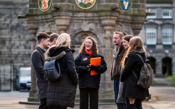 Edinburgh underground vaults with ghost tour guide and group exploring haunted history.