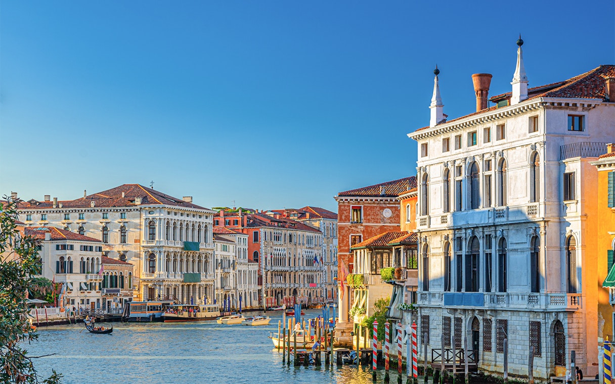 Ca' Rezzonico along the Grand Canal in Venice with gondolas and historic buildings.