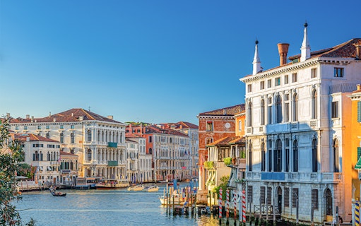 Ca' Rezzonico along the Grand Canal in Venice with gondolas and historic buildings.