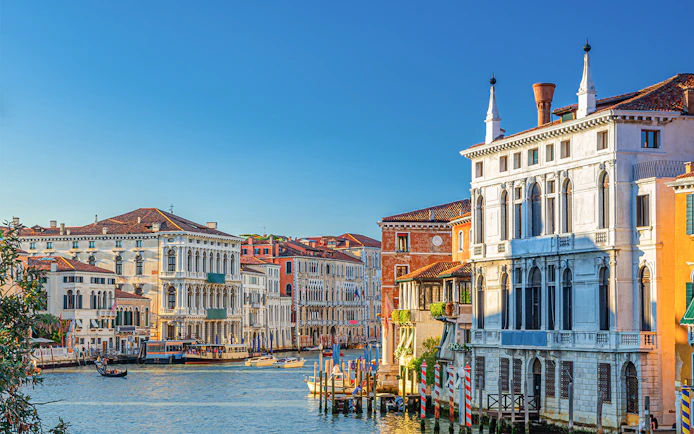 Ca' Rezzonico along the Grand Canal in Venice with gondolas and historic buildings.
