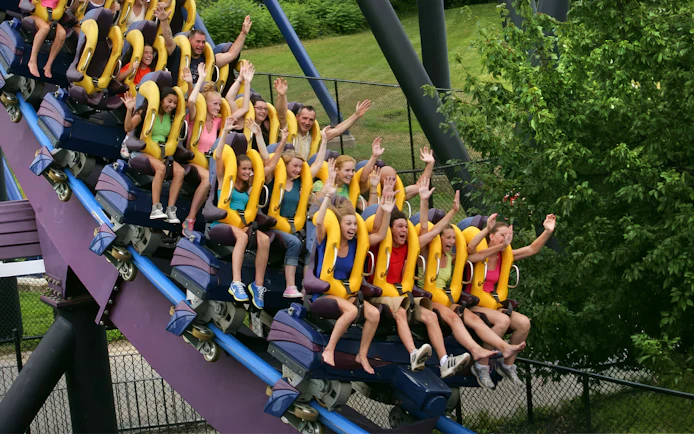 Riders enjoying BATMAN THE DARK KNIGHT™ roller coaster at Six Flags New England near Boston.