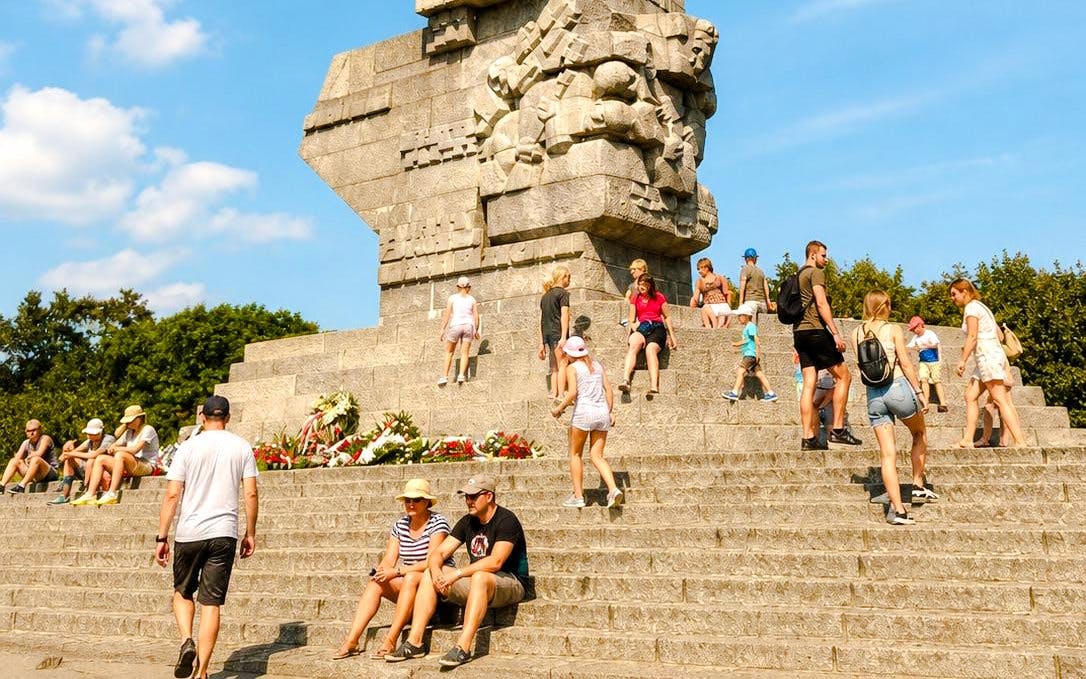 Visitors at Westerplatte Monument in Gdansk, Poland, sitting and walking on the steps.