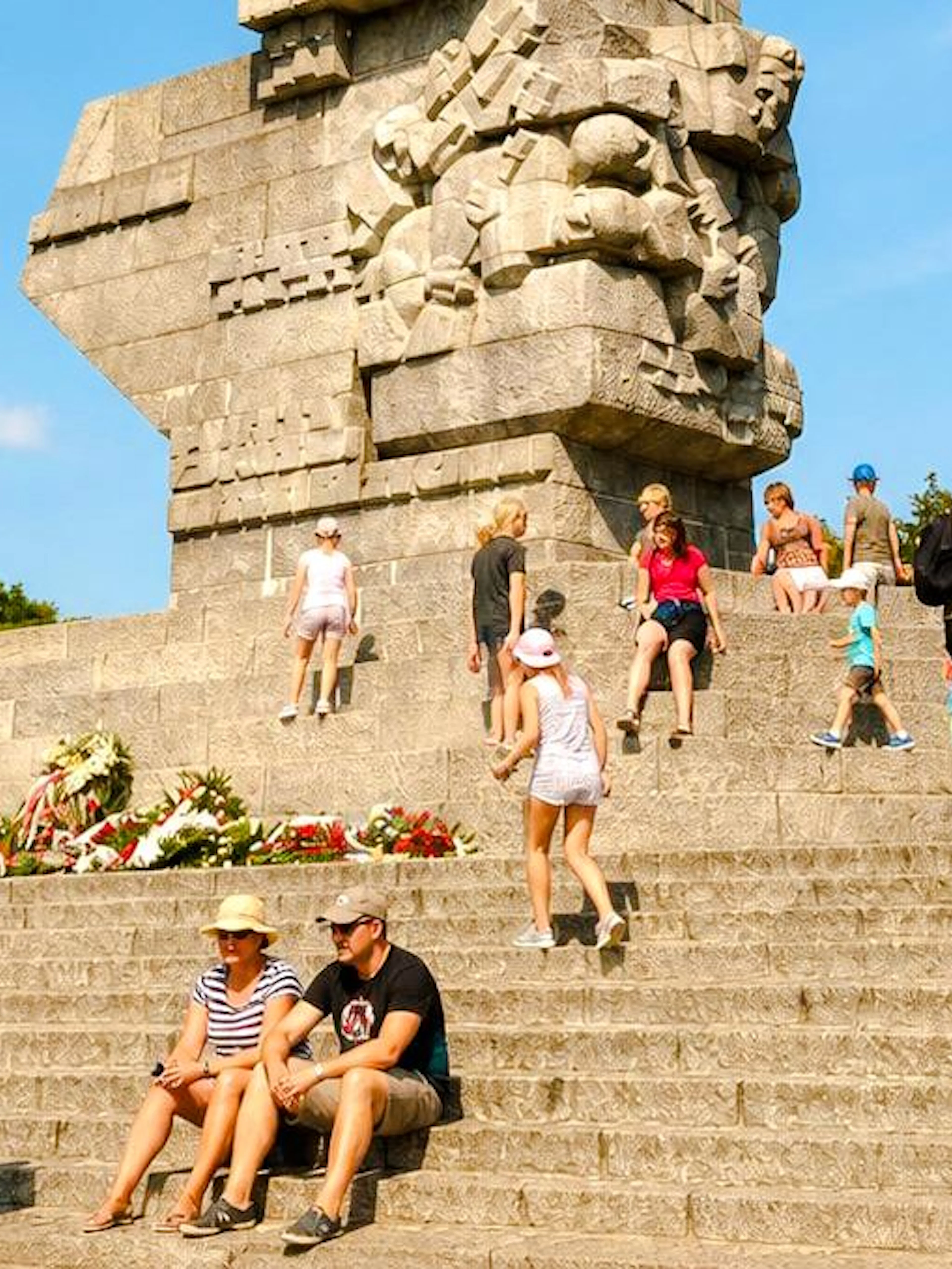 Visitors at Westerplatte Monument in Gdansk, Poland, sitting and walking on the steps.