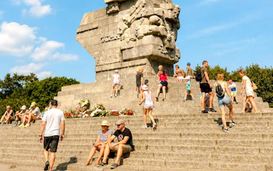 Visitors at Westerplatte Monument in Gdansk, Poland, sitting and walking on the steps.