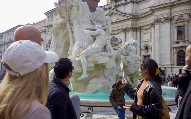 Tourists viewing the Fountain of the Four Rivers in Piazza Navona, Rome.