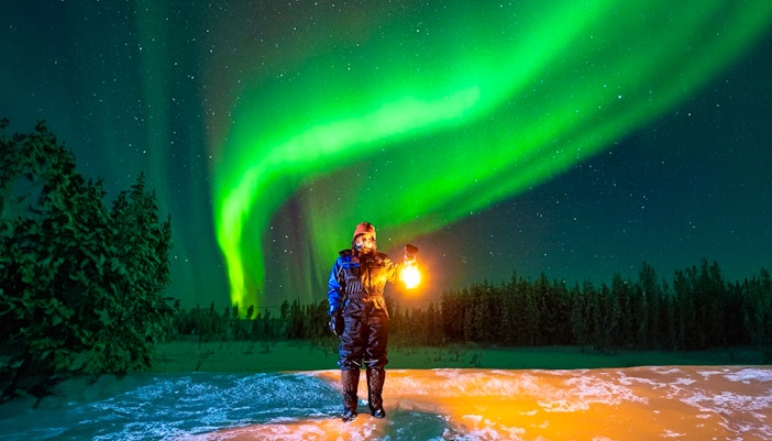 Guest photographing Northern Lights on Aurora expedition in Rovaniemi, Finland.