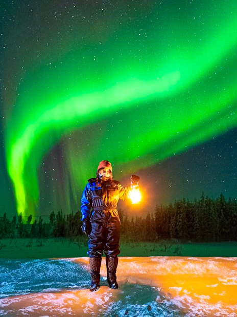 Guest photographing Northern Lights on Aurora expedition in Rovaniemi, Finland.