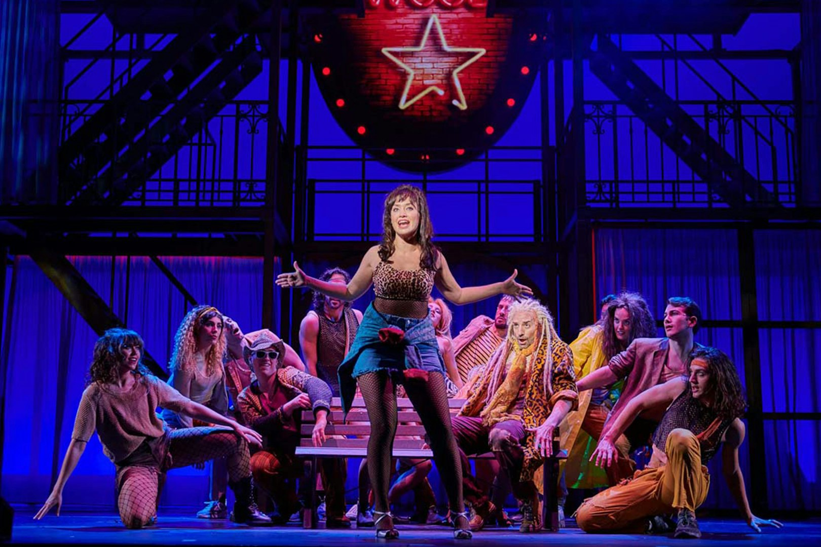 Performers on stage during "Pretty Woman - El musical" with vibrant lighting.