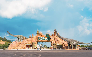 Entrance to Dino Desert with large dinosaur sculptures and ticketing counter.