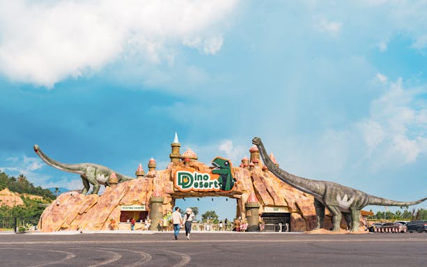 Entrance to Dino Desert with large dinosaur sculptures and ticketing counter.