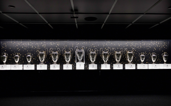 Trophies displayed in a row at Santiago Bernabéu Stadium.