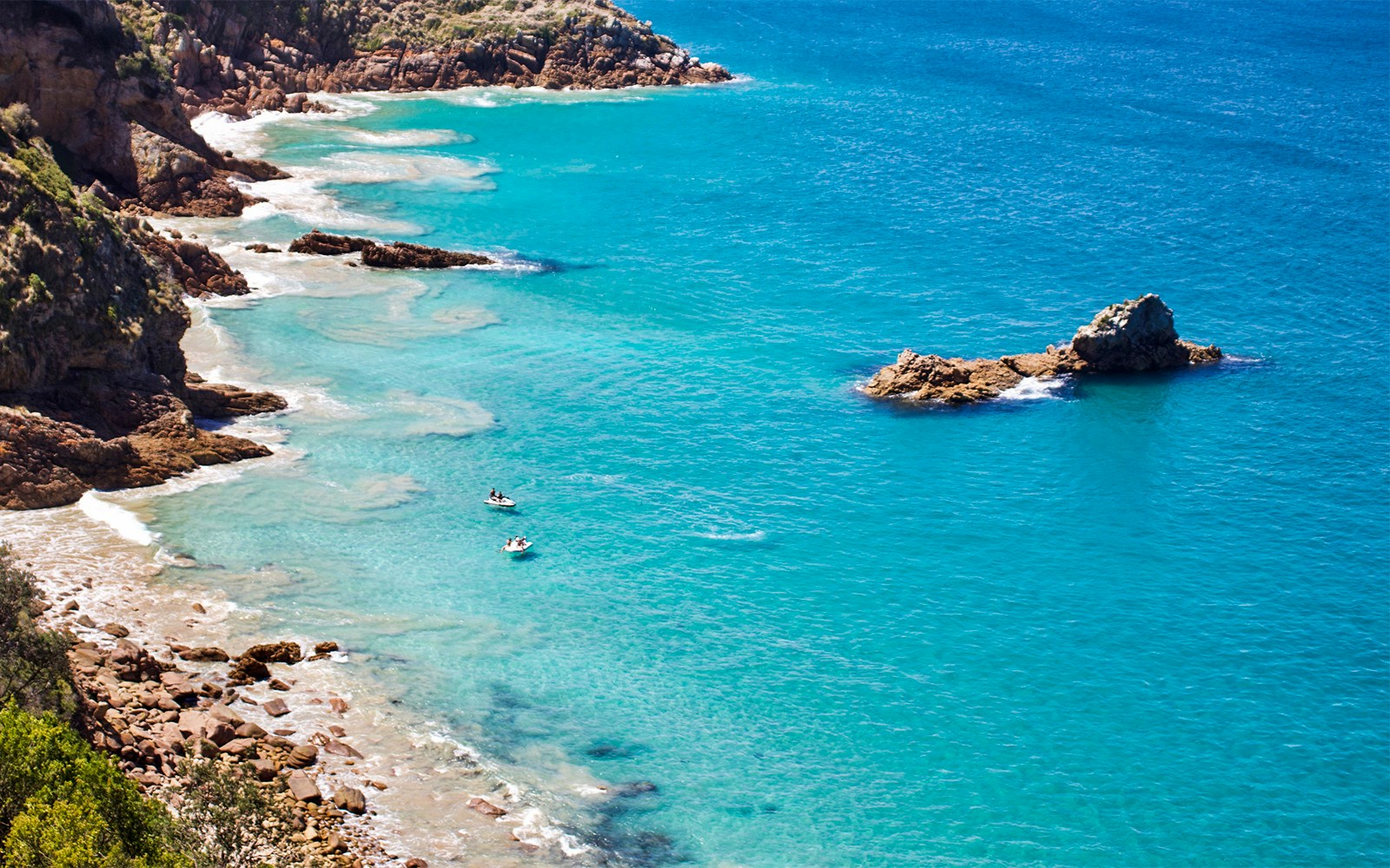Jet skis near rocky coastline of Moreton Island, Australia.