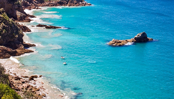 Jet skis near rocky coastline of Moreton Island, Australia.