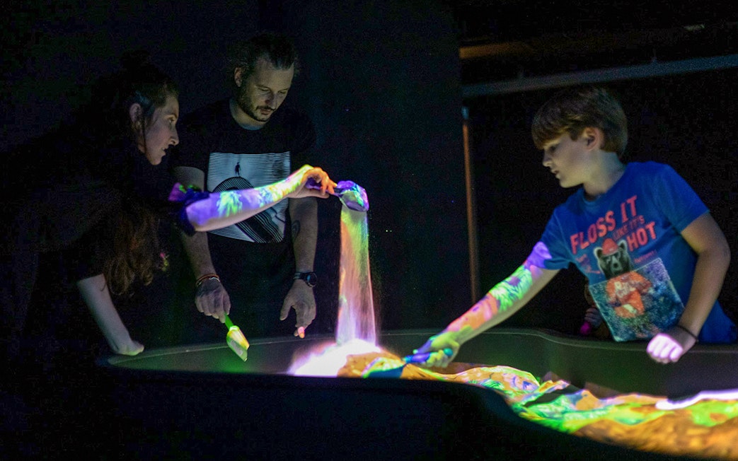 Visitors interacting with light art installation at Lumia Gallery exhibition.