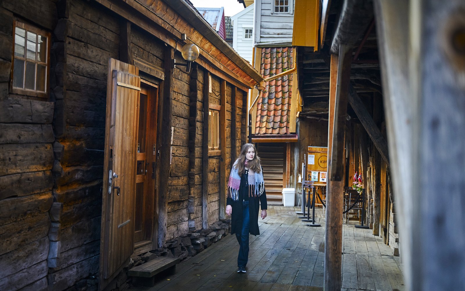 Guest walking through historic wooden alley in Bergen, Norway.