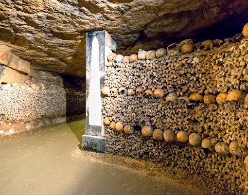Skulls and bones lining the walls of the Paris Catacombs.