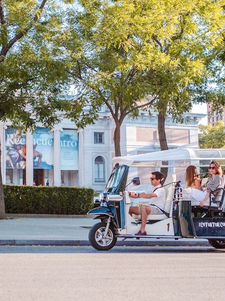 Electric tuk-tuk tour in Madrid passing the Prado Museum.